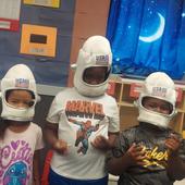 Children in astronaut helmets during space week